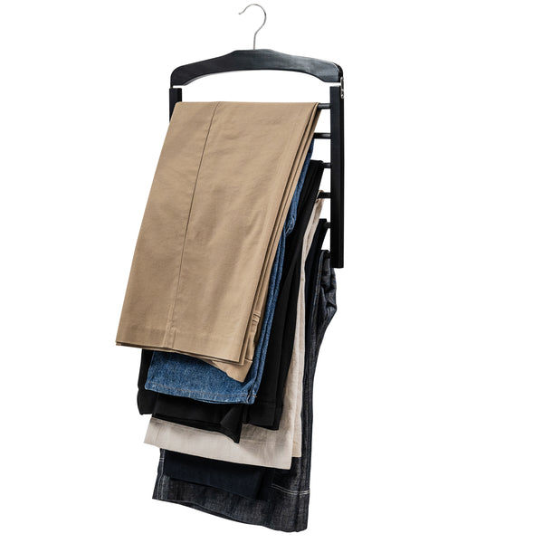 Multi-layer wooden pants hanger holding assorted trousers and jeans on white background