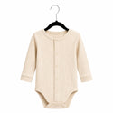 Beige baby bodysuit on a hanger against a white background