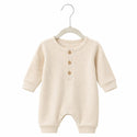 Beige baby romper on a hanger against a white background