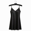 Black satin slip dress on a hanger against a white background