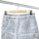 Blue paisley patterned shorts on a hanger against a white background