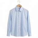 Light blue dress shirt on a wooden hanger against a white background