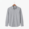 Gray button-up shirt on a wooden hanger against a white background
