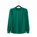 Green blouse on a hanger against a white background