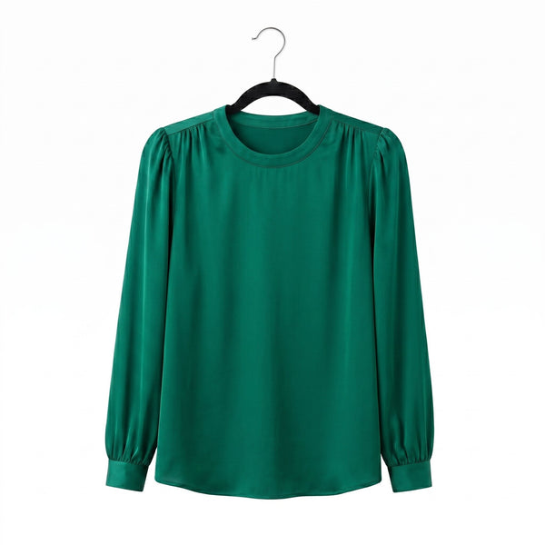 Green blouse on a hanger against a white background
