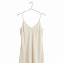 A beige colour dress hang on a chrome metal hanger