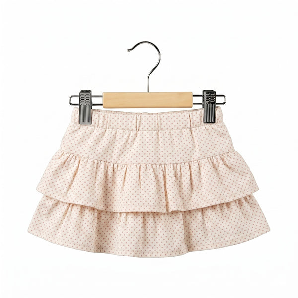 Three-layered skirt with a subtle pattern on a hanger against a white background