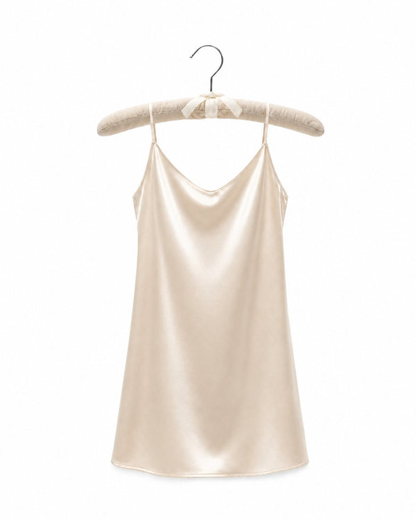 Beige satin slip dress on a hanger against a white background