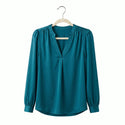 Teal blouse on a hanger against a white background