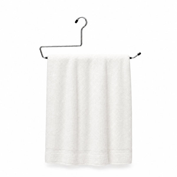 White towel hanging on a black metal towel rack against a white background