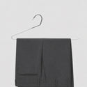 Gray pants on a hanger against a light gray background