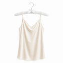Beige satin camisole on a hanger against a white background