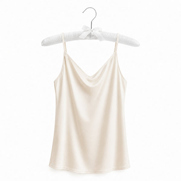 Beige satin camisole on a hanger against a white background